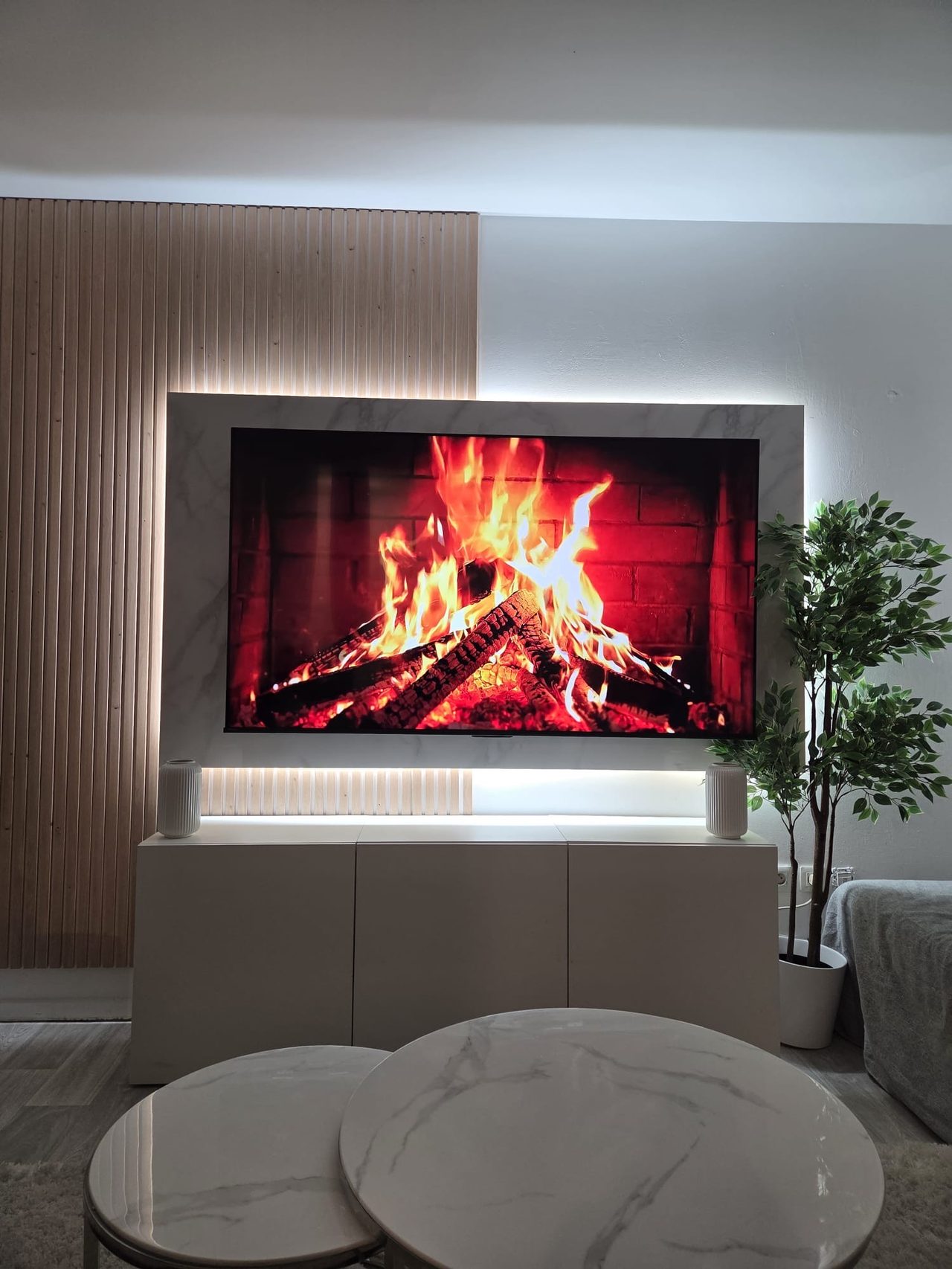Mur TV avec tasseaux bois, panneau effet marbre et rétroéclairage LED réalisé par Sylla Industrie